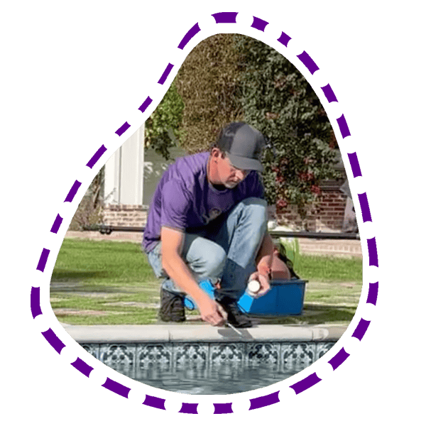Pool Service technician in phoenix arizona testing pool water checmical readings by the edge of a pool 